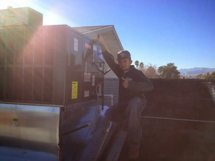 HVAC technician performing Boiler Repair on a rooftop unit in Pleasanton